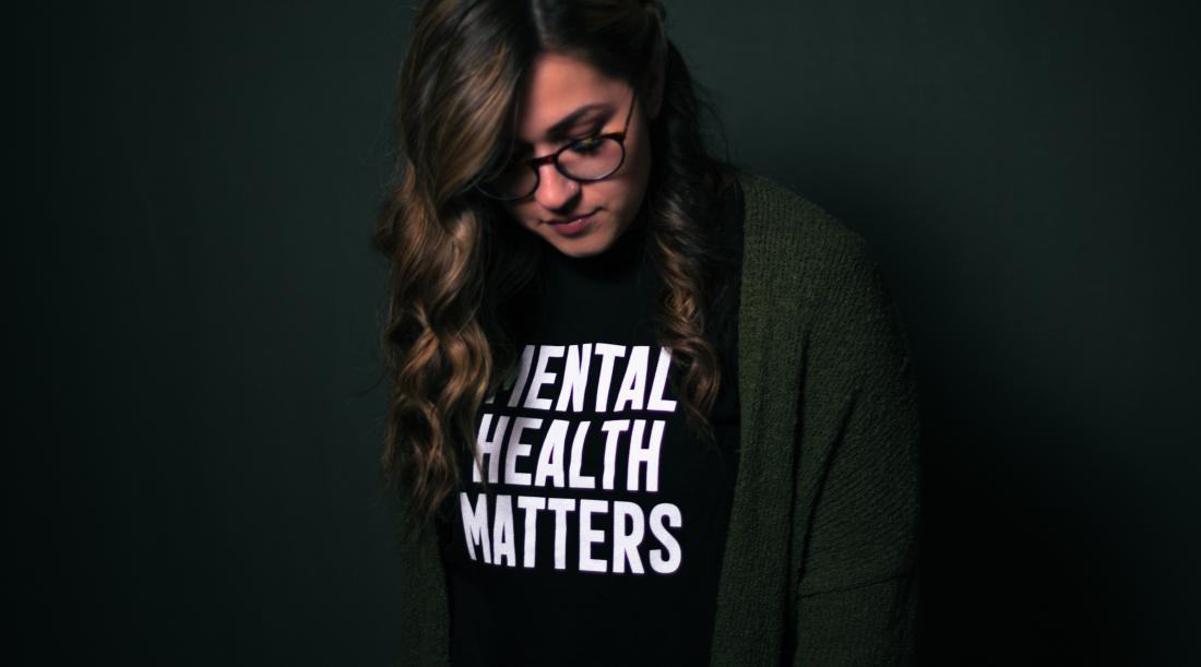 Depressed woman wearing a shirt that says "Mental Health Matters"