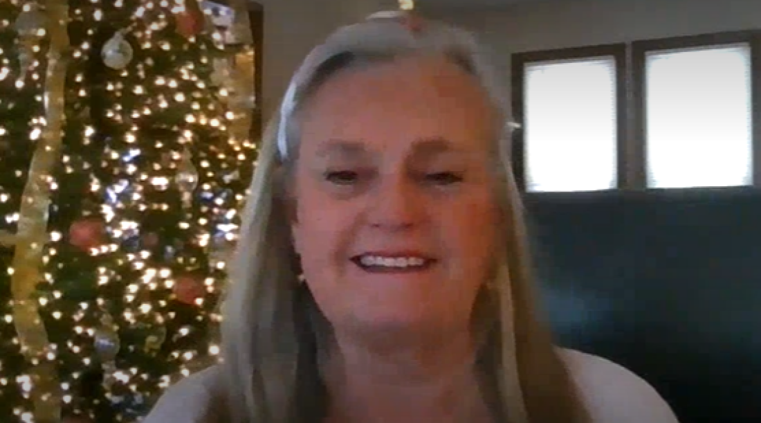 Photo of Tamie Hooper a white woman with long gray hair and a big smile. 